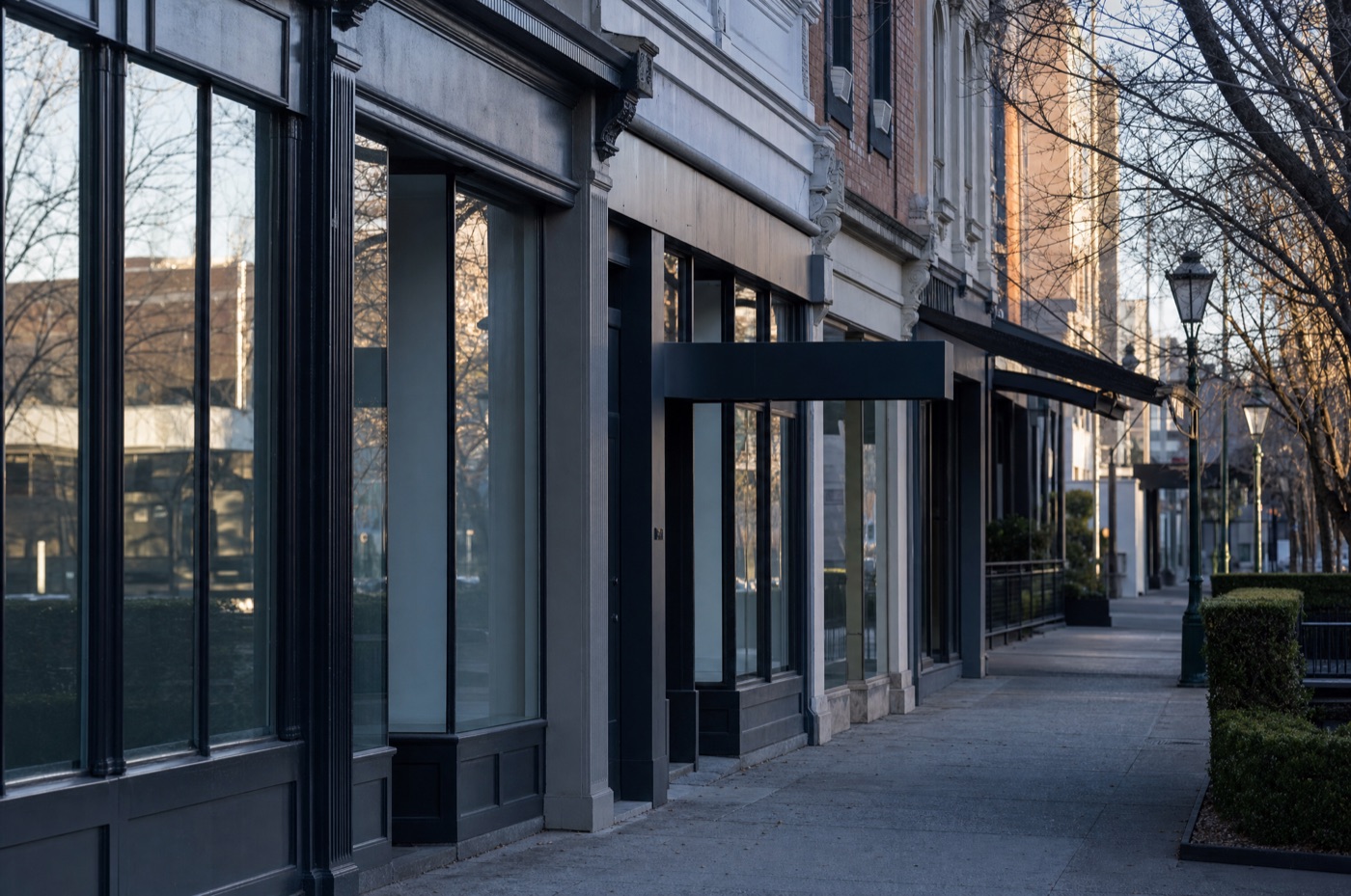 A row of Melbourne commercial shopfronts and a leased retail premises on a quiet inner-city street at early morning
