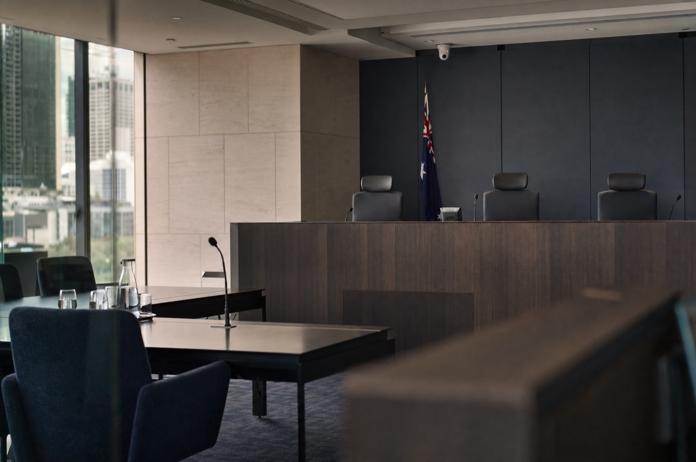 A modern VCAT hearing room in Melbourne with a raised member's bench and empty applicant tables